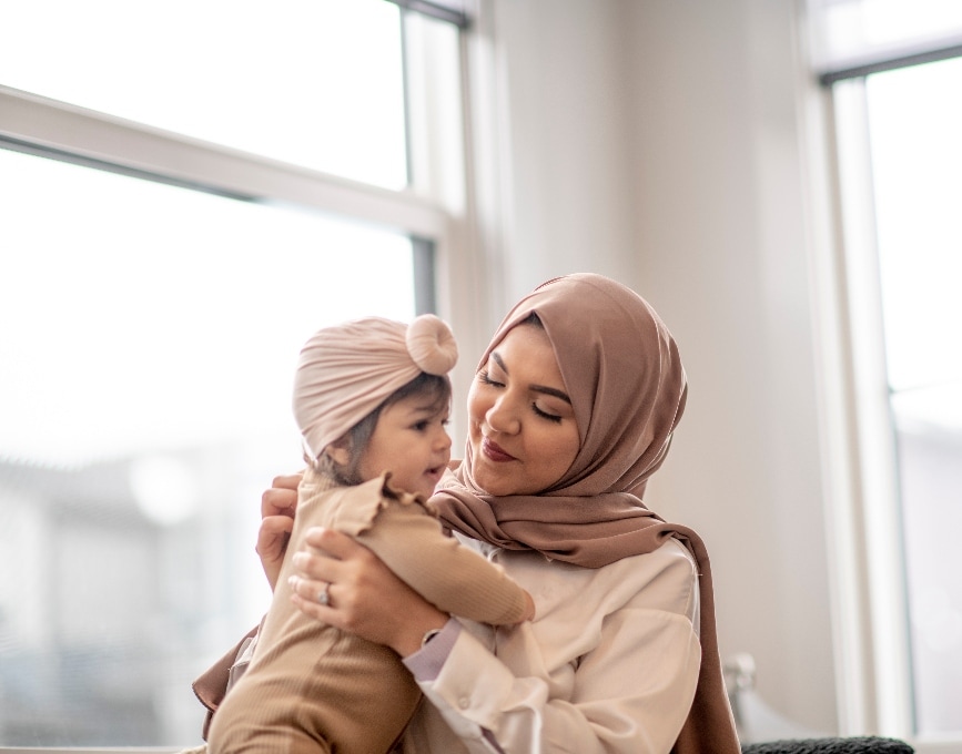 Woman sat in an office holding her baby